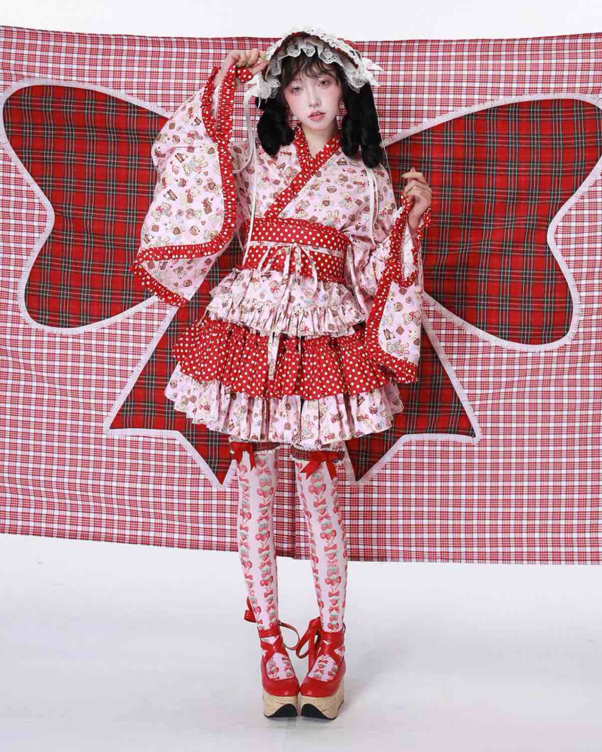 Person wearing a red and white polka dot dress with a large butterfly wings costume against a checkered background.