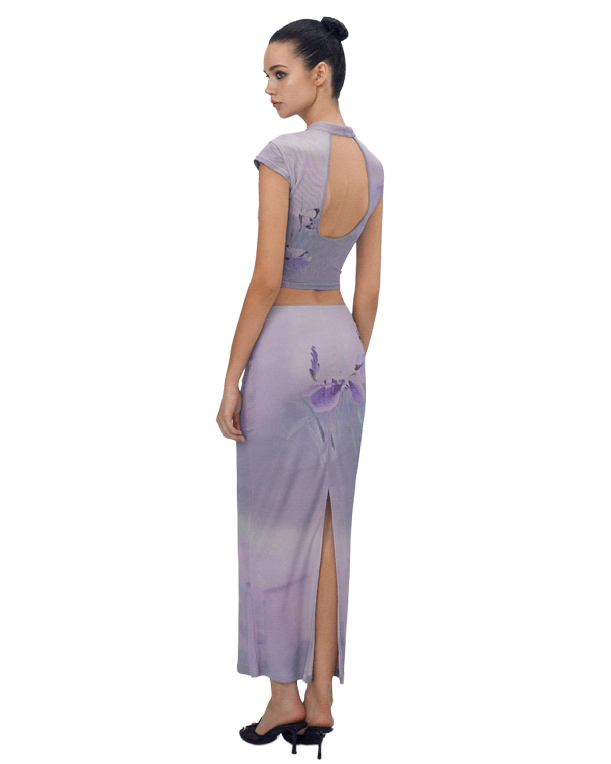 Woman wearing a lavender dress with floral designs on a white background
