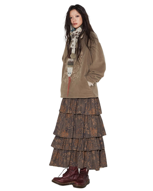 Person wearing a layered outfit with a jacket and skirt on a white background