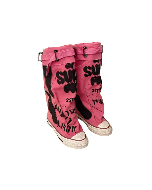 Pink boots with black text and designs on a white background