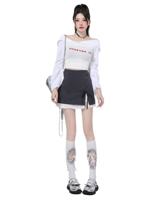 Person wearing a white off-shoulder top with text, black skirt, and ripped white socks on a white background
