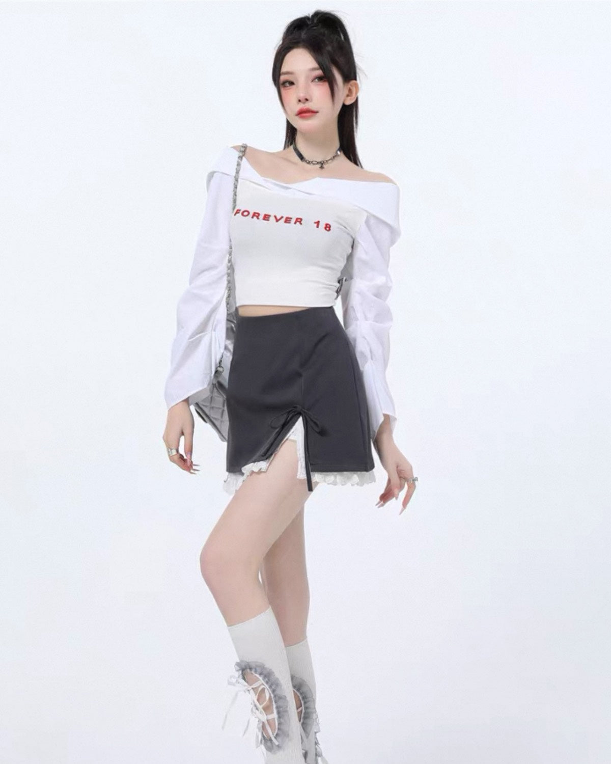 Woman wearing a white off-shoulder top with text and a black skirt on a white background