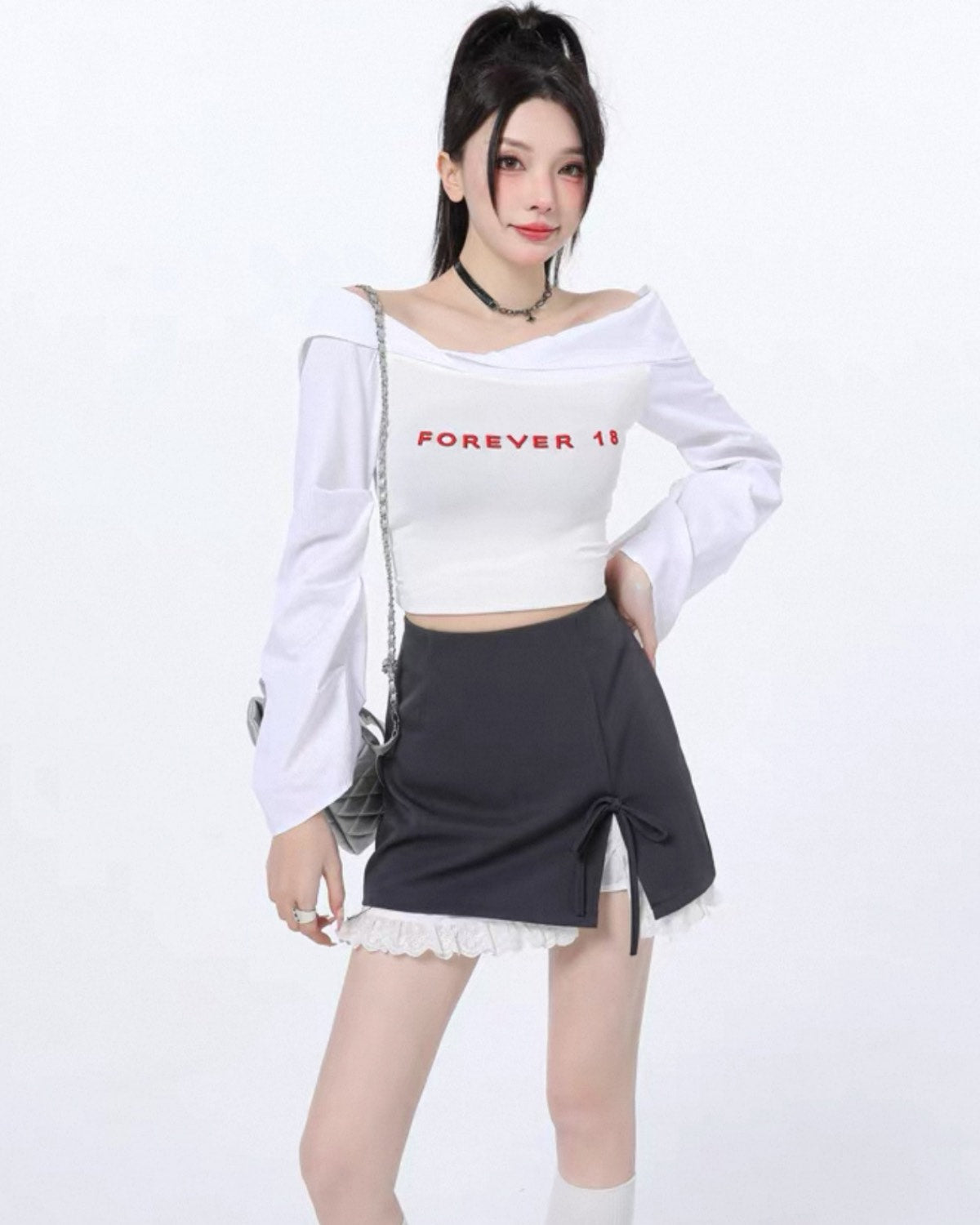Woman wearing a white crop top with red text and a black skirt on a white background