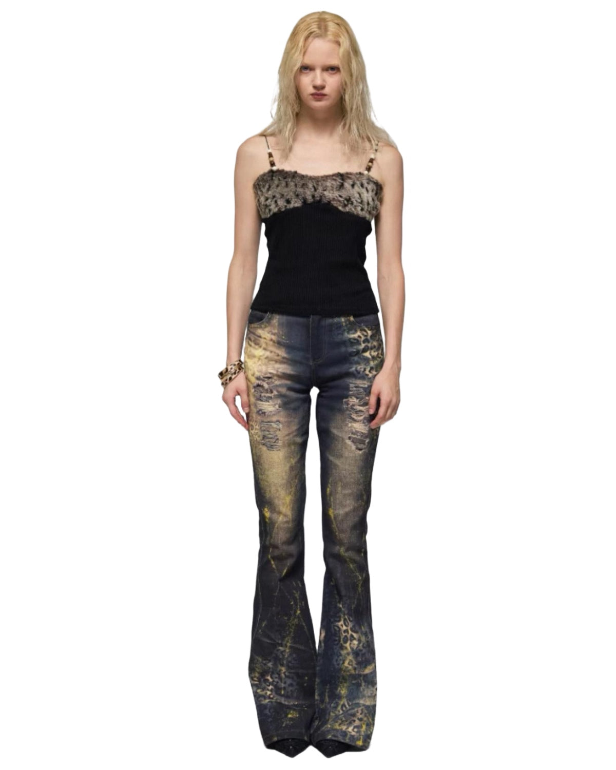 Woman wearing a black top and distressed flared jeans on a white background