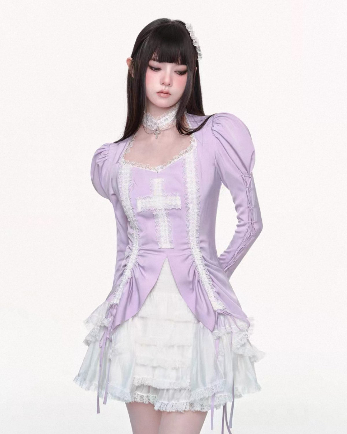 Person wearing a lavender top with puffed sleeves and a white dress underneath on a white background
