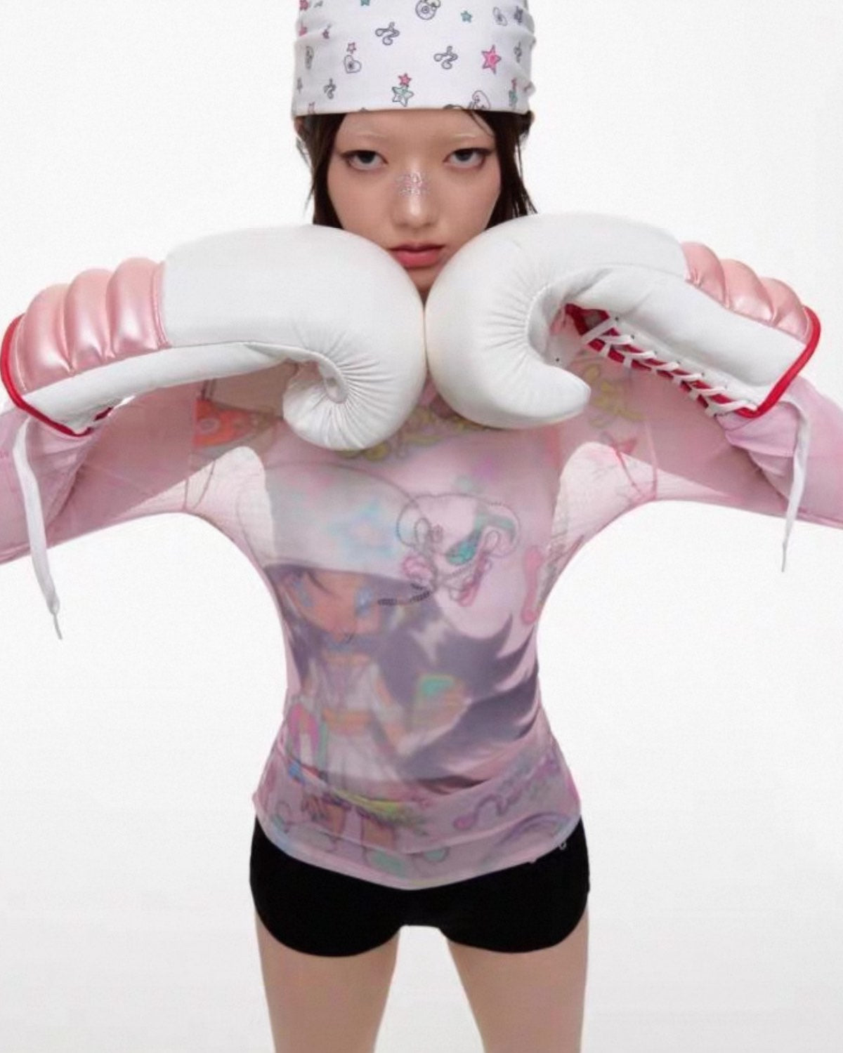 Person wearing pink boxing gloves and a matching outfit with cartoon designs on a white background