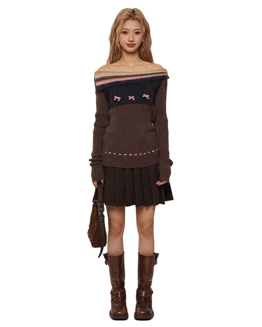 Woman wearing a brown sweater with a boat neckline and pleated skirt on a white background