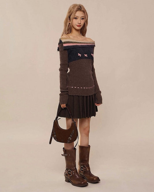 Woman wearing a brown off-shoulder sweater, black pleated skirt, and brown boots against a beige background