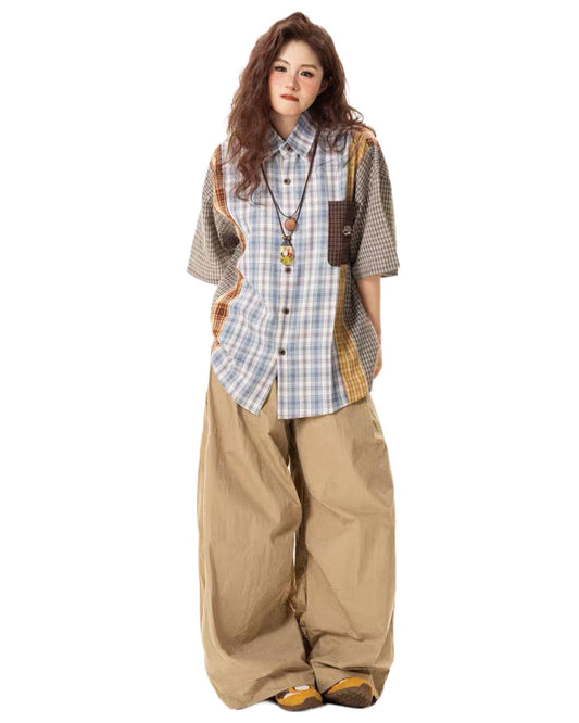 Woman wearing a plaid shirt and beige pants on a white background