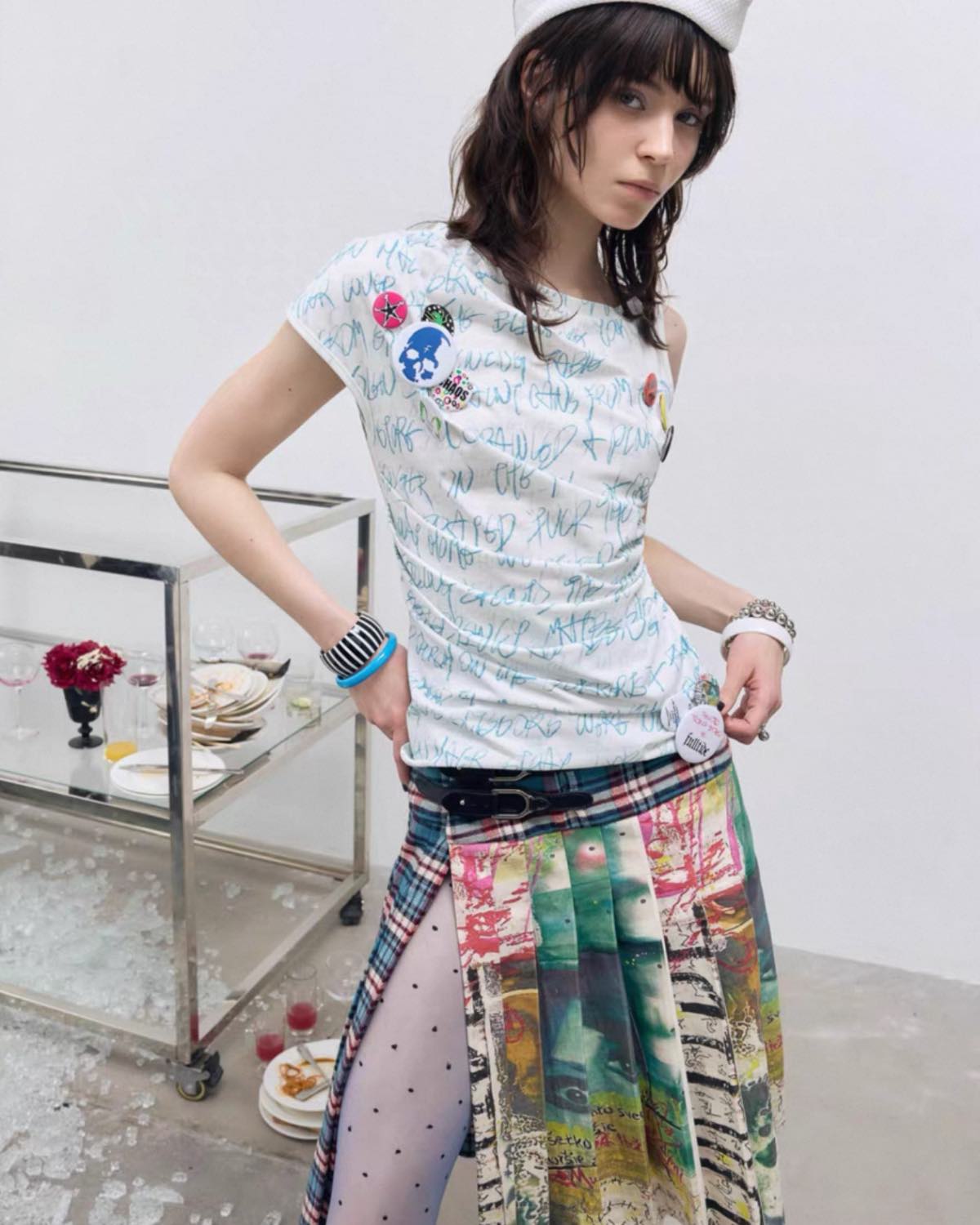 Person wearing a patterned shirt and colorful skirt in an indoor setting