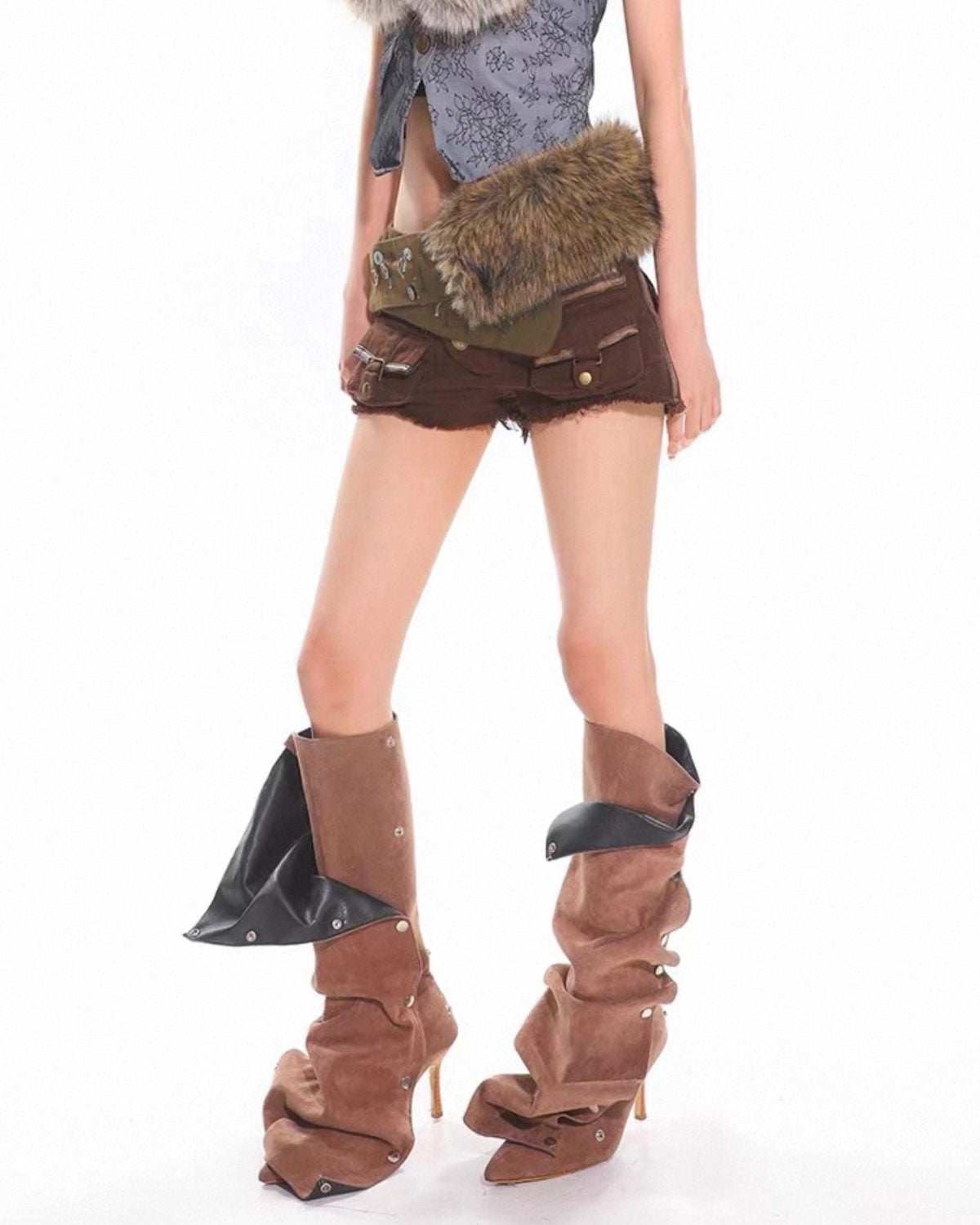 Person wearing brown high-heeled boots with black accents on a white background