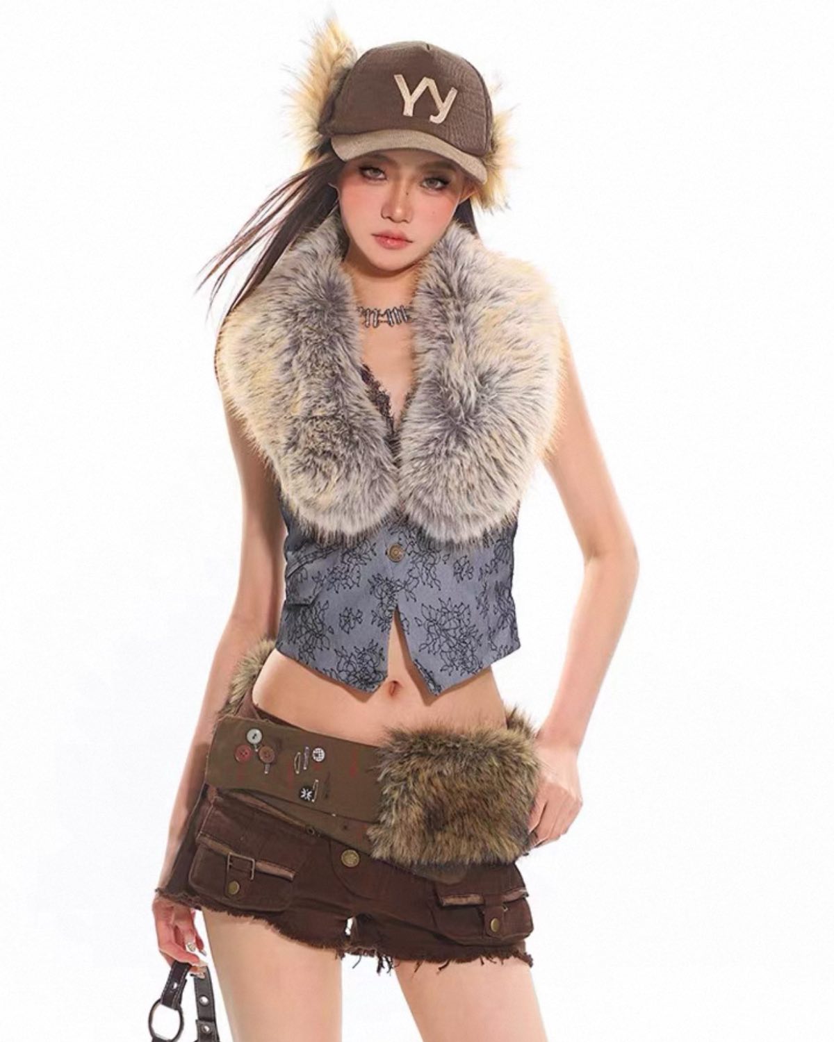 Person wearing a stylish outfit with a fur vest and cap on a white background