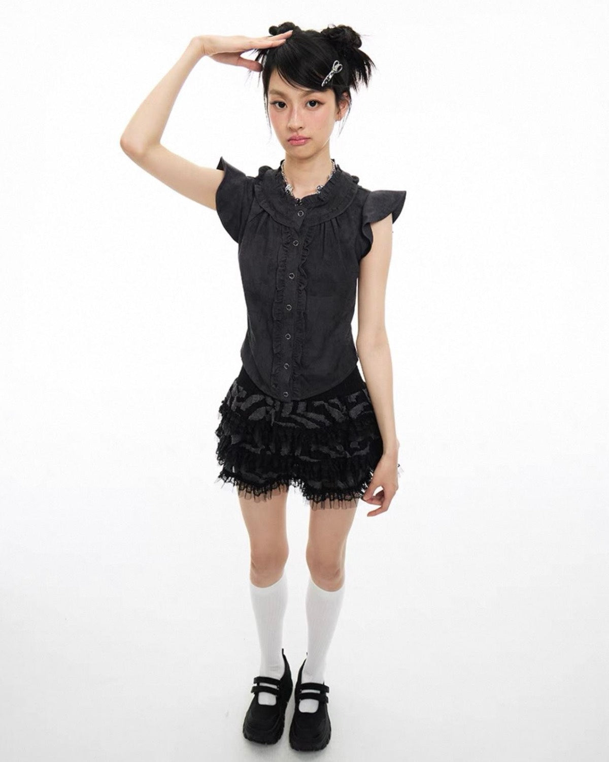 Person wearing a black outfit with a skirt on a white background