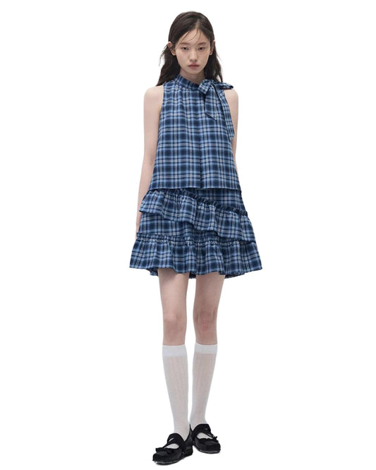 Girl wearing a blue plaid dress on a white background