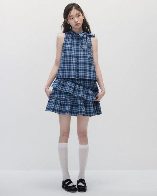 Girl wearing a blue plaid dress on a white background