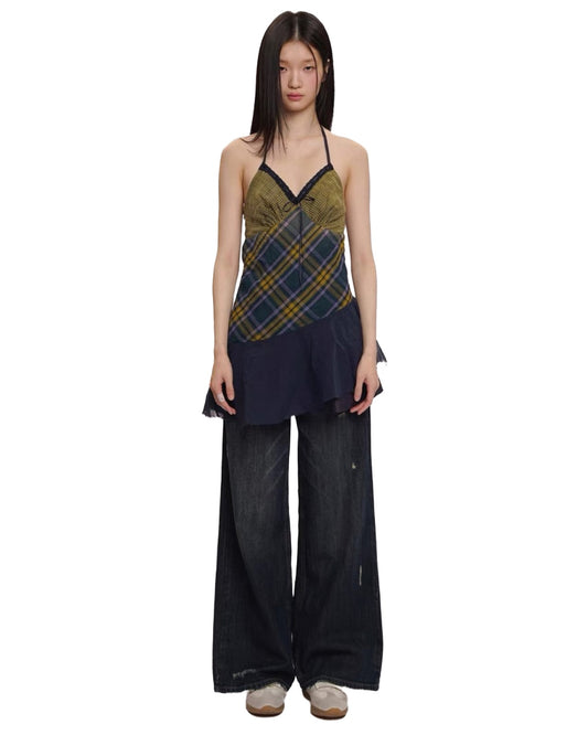 Woman wearing a plaid top and black pants on a white background
