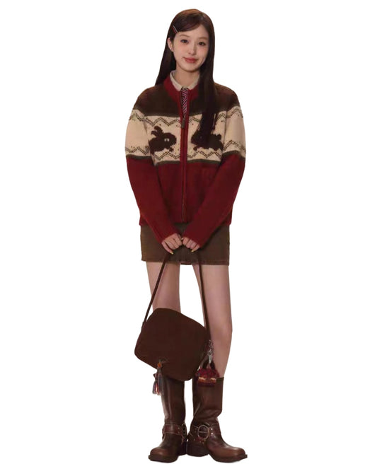 Person wearing a patterned sweater with a brown bag and boots on a white background
