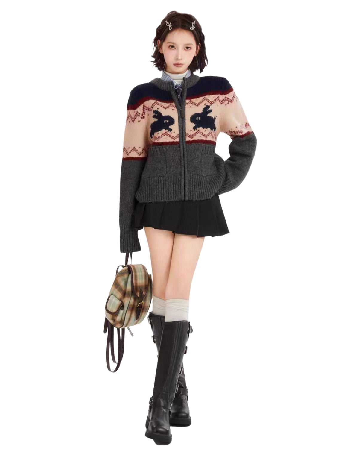 Woman wearing a patterned sweater with a plaid bag on a white background