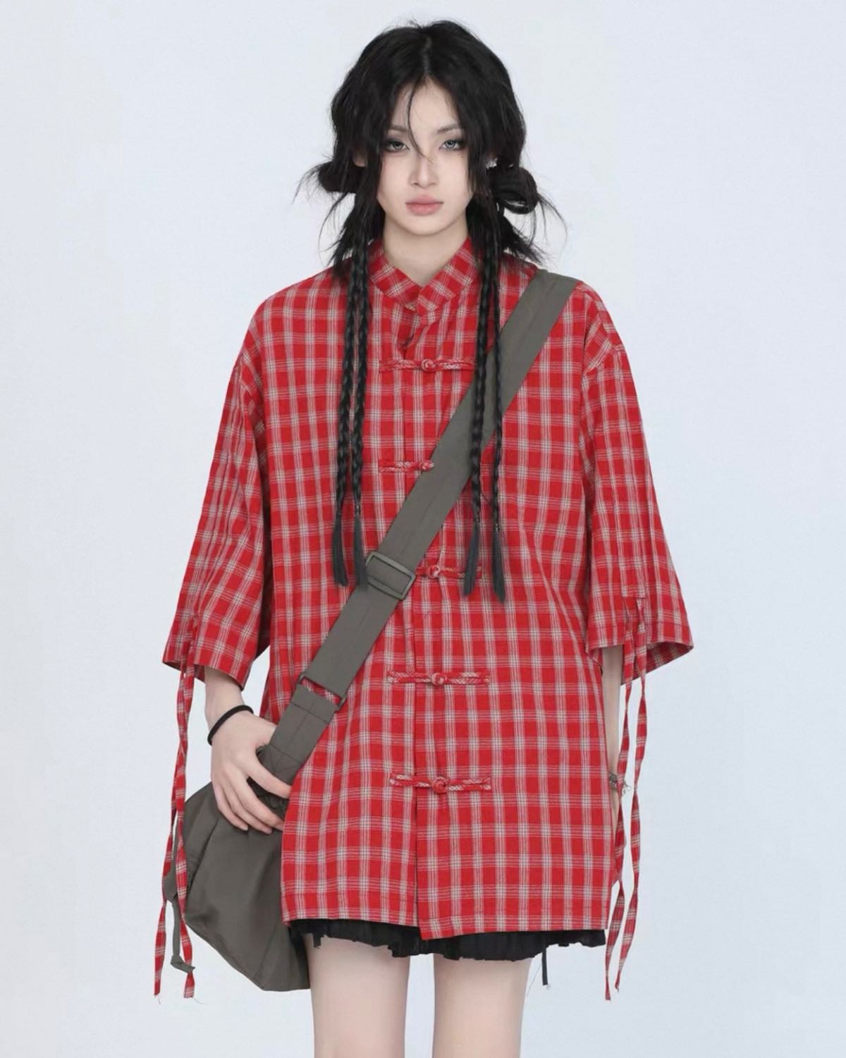 Person wearing a red plaid dress with a brown bag on a white background