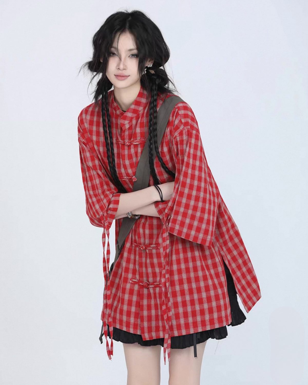 Person wearing a red and white checkered shirt with a plain background