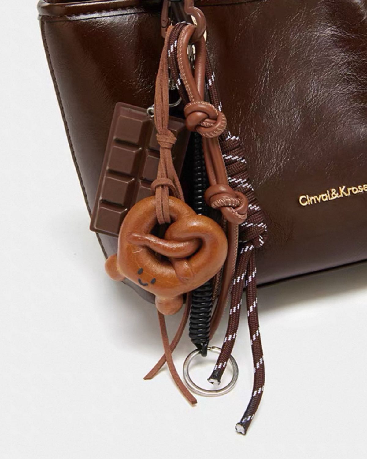 Brown leather keychain with decorative elements on a white background