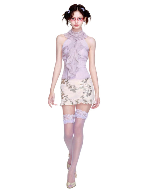 Woman wearing a light purple top and floral skirt with matching accessories on a white background