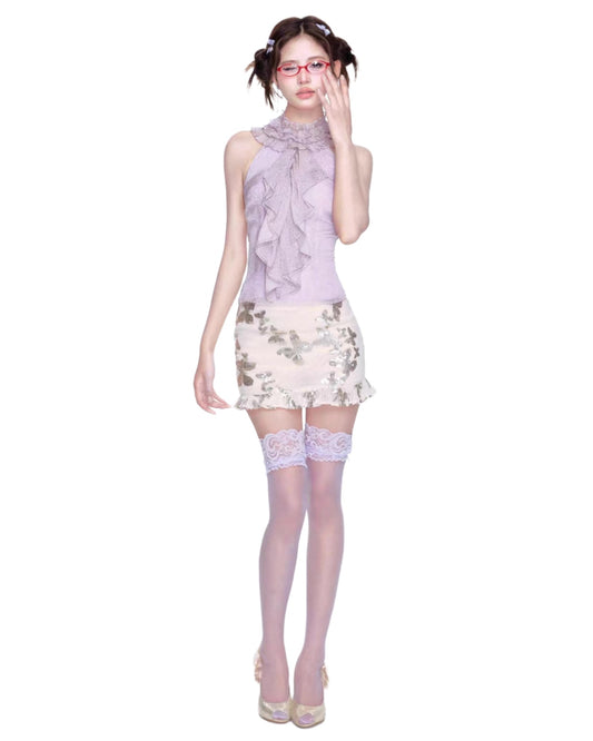 Woman wearing a floral dress with a sheer overlay on a white background