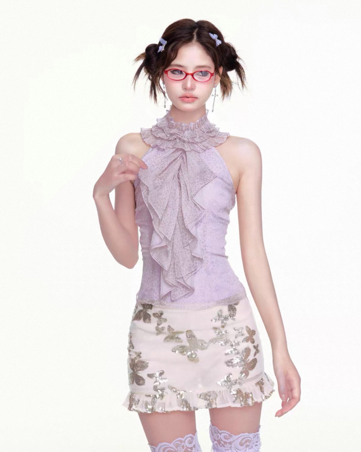 Woman wearing a light purple lace top and floral skirt on a white background