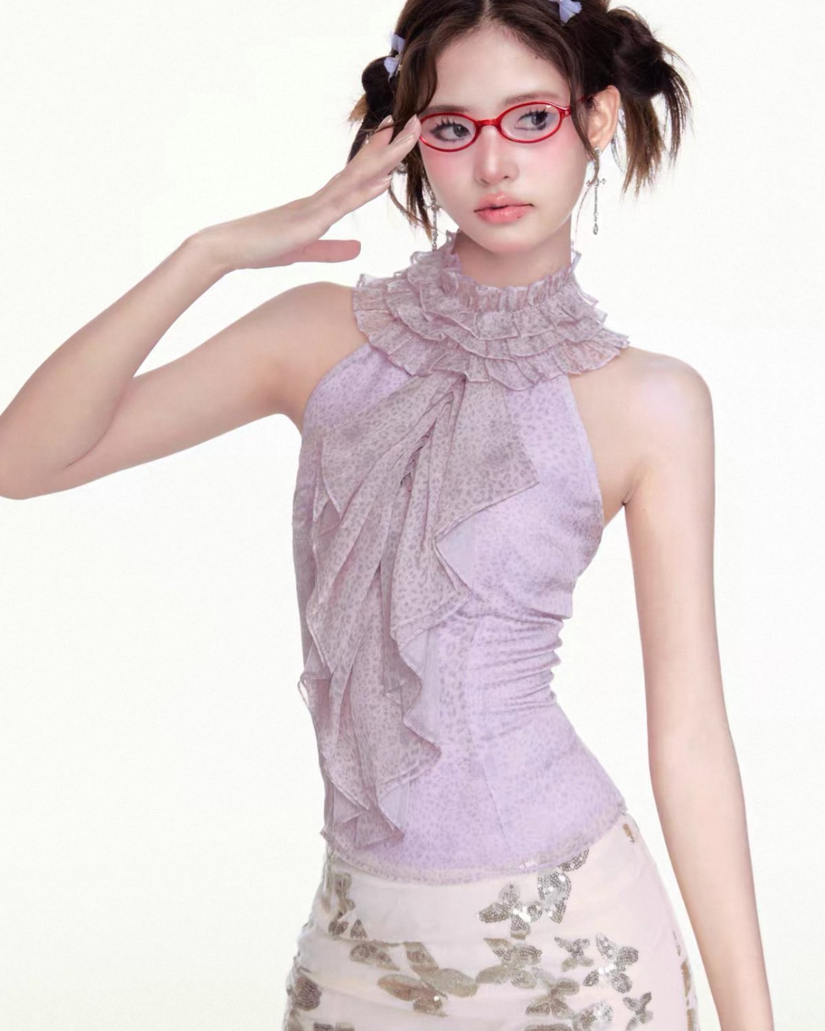 Woman wearing a light purple top with ruffled details on a white background
