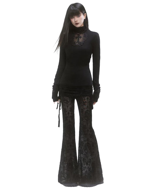 Woman wearing a black long-sleeve top and black flared pants on a white background