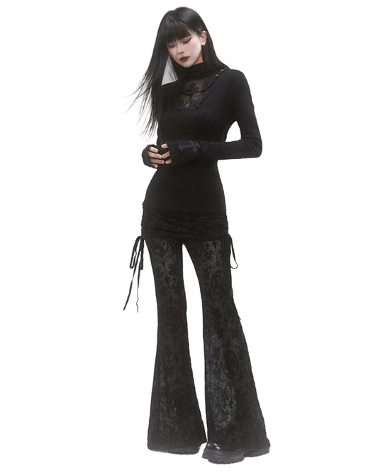 Woman wearing a black outfit with lace details on a white background