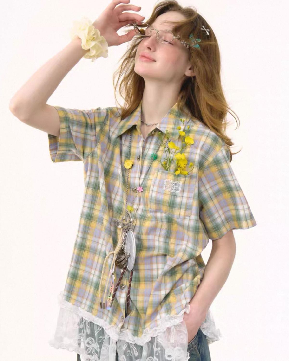 Woman wearing a plaid shirt with lace details on a white background