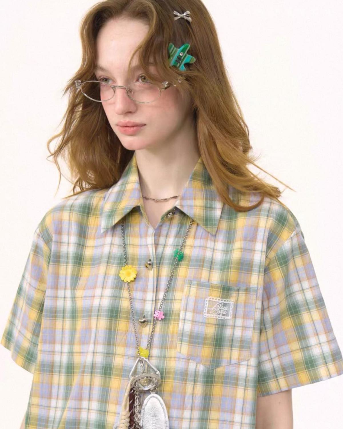 Person wearing a plaid shirt with a white background
