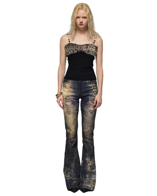 Woman wearing a black top and distressed flared jeans on a white background