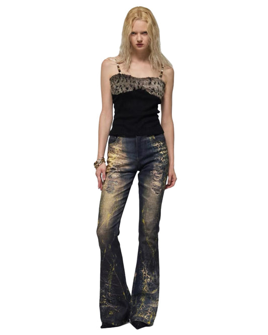 Woman wearing a black top with animal print and distressed jeans on a white background