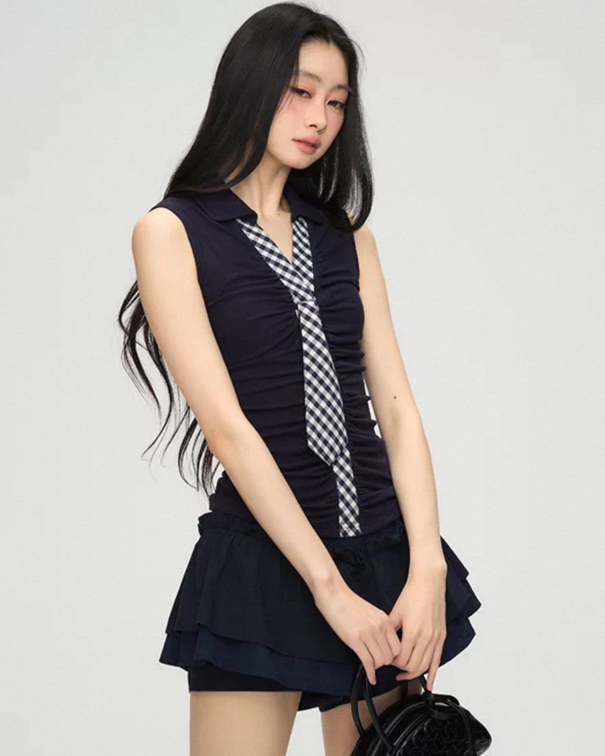 Woman wearing a navy blue dress with a checkered pattern on a white background