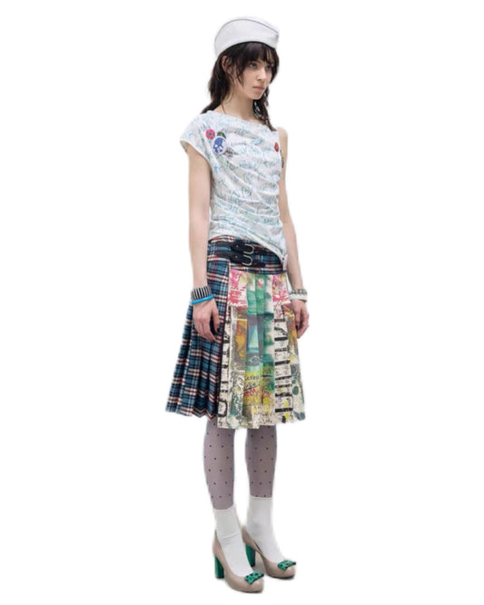 Person wearing a patterned top and plaid skirt on a white background