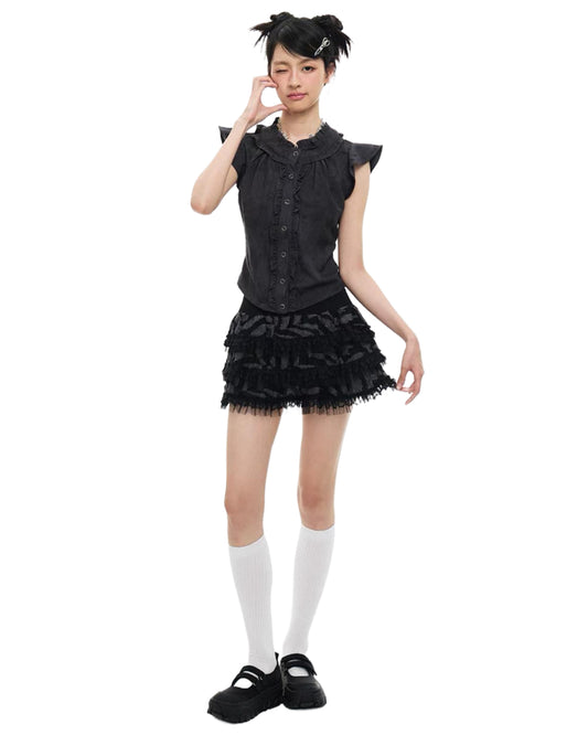 Person wearing a black dress with ruffled details on a white background
