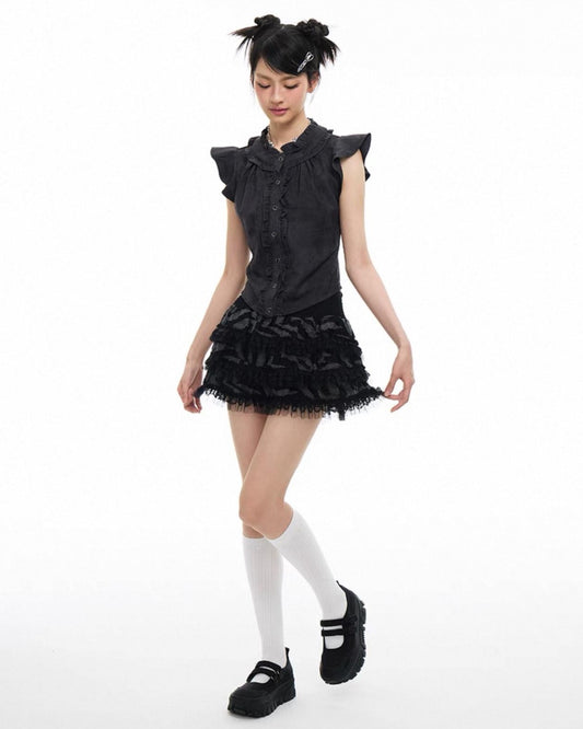 Person wearing a black dress with ruffled details on a white background