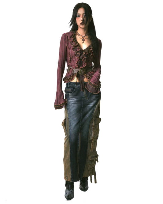 Woman wearing a steampunk-style outfit with a ruffled top and long skirt on a white background